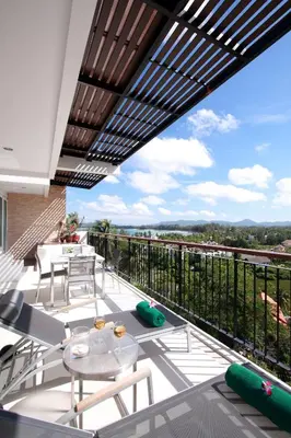 a balcony with a table and chairs and a view at The Park Surin Serviced Apartments by RESAVA in Surin Beach