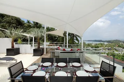 a dining room with a table and chairs at The Park Surin Serviced Apartments by RESAVA in Surin Beach