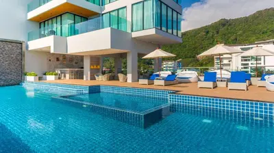 a swimming pool in front of a building at Grand Kata VIP - Kata Beach in Kata Beach