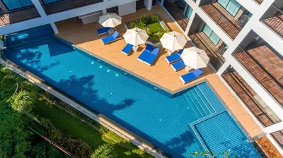 an overhead view of a swimming pool with chairs and umbrellas at Grand Kata VIP - Kata Beach in Kata Beach