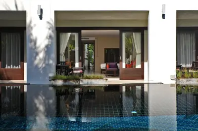 a house with a swimming pool in front of a house at Tea Tree Boutique Resort in Rawai Beach