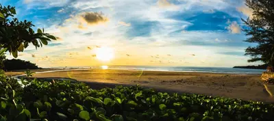 a view of a beach at sunset at Layalina Hotel in Kamala Beach