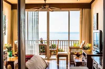 a bedroom with a view of the ocean from a balcony at Layalina Hotel in Kamala Beach