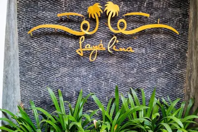 a sign for the royal alcazar with green plants at Layalina Hotel in Kamala Beach