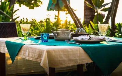 a table with a blue table cloth and a plate of food at Layalina Hotel in Kamala Beach