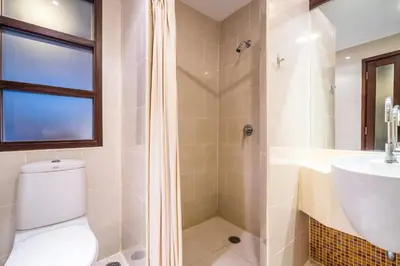 a bathroom with a shower and a toilet and a sink at Baan Suwantawe in Phuket Town