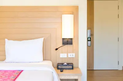 a bedroom with a bed and a lamp on a table at Baan Suwantawe in Phuket Town