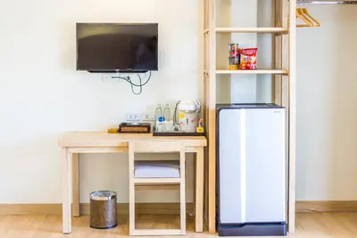 a desk with a tv and a refrigerator in a room at Baan Suwantawe in Phuket Town