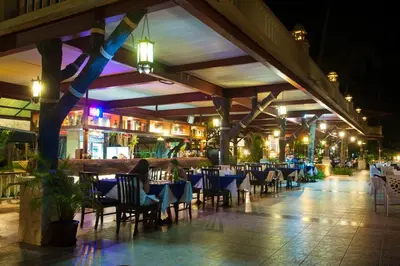 an empty restaurant with tables and chairs at night at Phi Phi Island Cabana Hotel in Phi Phi Don