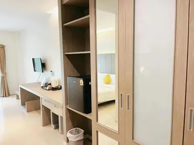 a room with a desk and a bookcase with a bed at Phuketa Hotel Phuket Town in Phuket Town