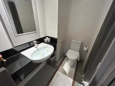 a bathroom with a sink and a toilet and a mirror at Phuketa Hotel Phuket Town in Phuket Town