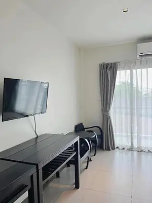 a living room with a table and a tv at Phuketa Hotel Phuket Town in Phuket Town
