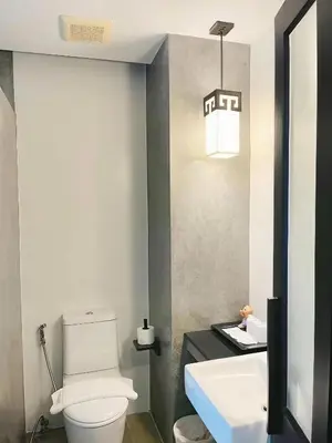 a bathroom with a white toilet and a sink at Phuketa Hotel Phuket Town in Phuket Town