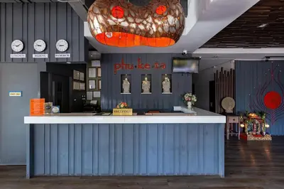 a bar in a building with a large clock at Phuketa Hotel Phuket Town in Phuket Town