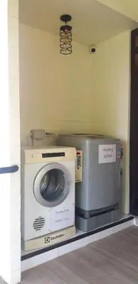 a washing machine sitting on a shelf in a room at Happy Cottage in Chalong