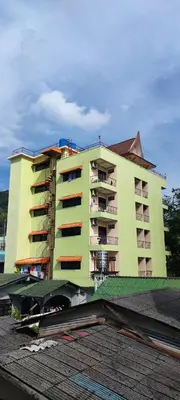 a large apartment building in front of a building at G&B Guesthouse in Patong Beach