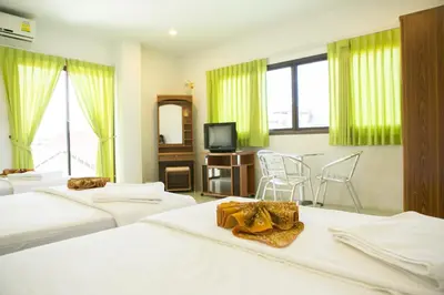a hotel room with two beds and a television at G&B Guesthouse in Patong Beach