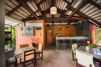 a dining room with a table and a bar at Phuket Monaburi Boutique Hotel in Rawai Beach