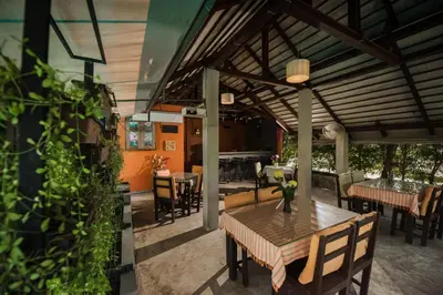 a patio with a wooden table and chairs at Phuket Monaburi Boutique Hotel in Rawai Beach