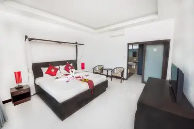 a bedroom with a large bed with red pillows at Phuket Monaburi Boutique Hotel in Rawai Beach