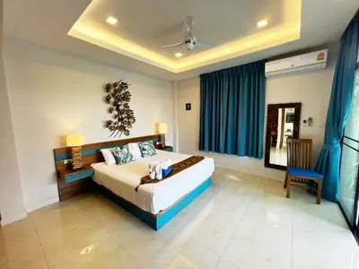 a bedroom with a bed and a blue curtain at Cozy Two Bedrooms Villa by G Estate in Rawai Beach