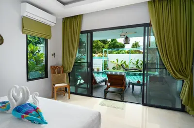 a bedroom with a bed and a view of a pool at Nenuphar Villa by G Estate in Rawai Beach