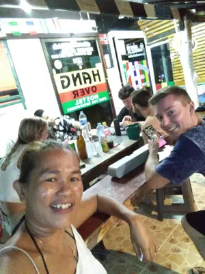 two people sitting at a table in a restaurant at Hangover Hostel in Phi Phi Don