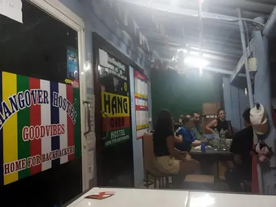a group of people sitting at a table in a restaurant at Hangover Hostel in Phi Phi Don