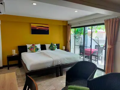 a bedroom with a bed and a yellow wall at Kamala Beachfront Apartment in Kamala Beach