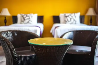 a table and chairs in a room with two beds at Kamala Beachfront Apartment in Kamala Beach
