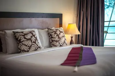 a hotel room with a bed with a purple ribbon on it at Kamala Beachfront Apartment in Kamala Beach