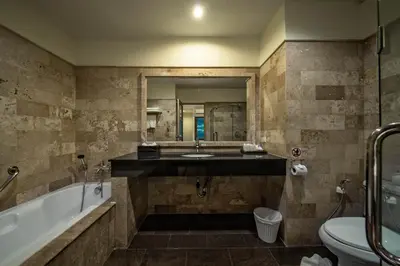a bathroom with a tub and a sink and a toilet at Kamala Beachfront Apartment in Kamala Beach