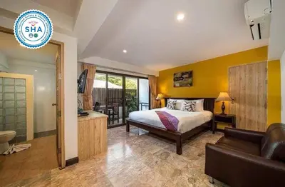 a bedroom with a bed and a couch in a room at Kamala Beachfront Apartment in Kamala Beach
