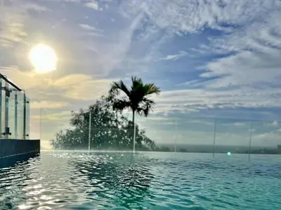 a palm tree in the middle of a swimming pool at Sunset Plaza by RESAVA in Karon Beach