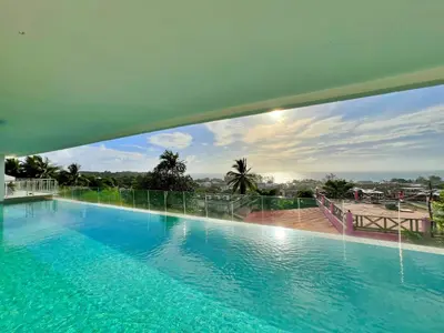 a large swimming pool with a view of the city at Sunset Plaza by RESAVA in Karon Beach