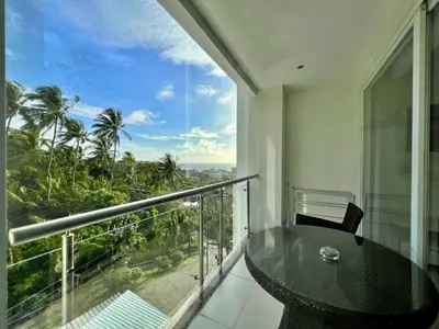 a balcony with a table and a view of the city at Sunset Plaza by RESAVA in Karon Beach