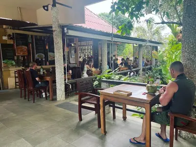 a man sitting at a table in a restaurant at Flora Ville-SHA PLUS in Chalong