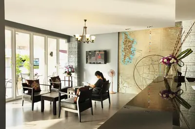 a woman sitting in a chair in a living room at Samkong Place in Phuket Town