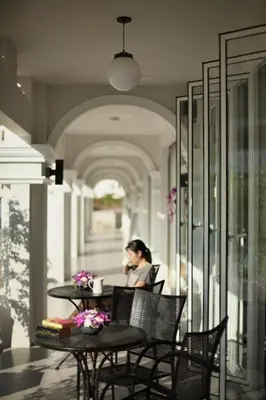 a woman sitting at a table in a restaurant at Samkong Place in Phuket Town