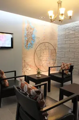 a waiting room with chairs and tables and a map on the wall at Samkong Place in Phuket Town