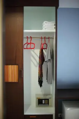 a room with a closet with a clock and towels at Samkong Place in Phuket Town
