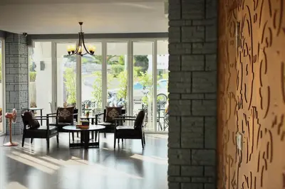 a room with a table and chairs and windows at Samkong Place in Phuket Town