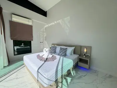 a bedroom with a bed with a flower on it at Skypool Villa by G Estate Phuket in Nai Harn Beach