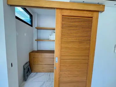 a wooden door in a room with a shelf at Skypool Villa by G Estate Phuket in Nai Harn Beach