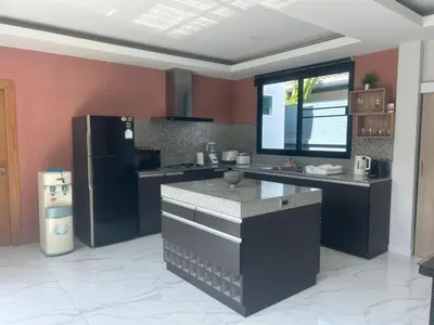 a kitchen with a black refrigerator and a counter at Skypool Villa by G Estate Phuket in Nai Harn Beach