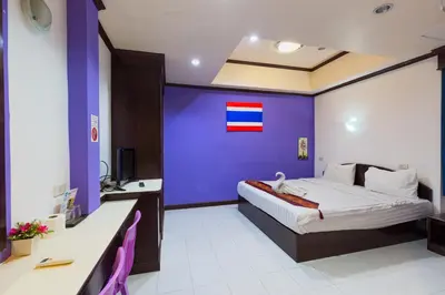 a hotel room with a bed with a purple wall at Grand Orchid Inn Patong beach in Patong Beach