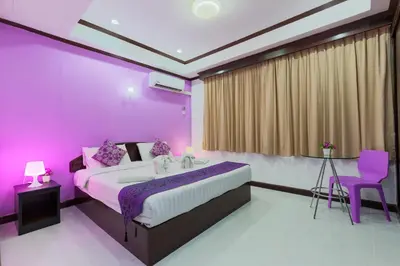 a purple bedroom with a bed and a sink at Grand Orchid Inn Patong beach in Patong Beach