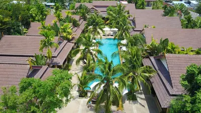 an aerial view of a resort swimming pool with palm trees at Le Piman Resort in Rawai Beach