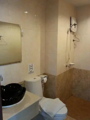 a bathroom with a toilet and a sink and a shower at C.A.P Mansion in Phuket Town