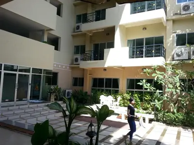 a man walks in front of a building at C.A.P Mansion in Phuket Town
